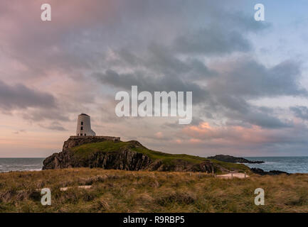 Il Llanddwyn Island Lighthouse, Twr Mawr a Ynys Llanddwyn su Anglesey, Galles del Nord a sunrise. Foto Stock