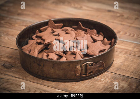 Natale dolci di panpepato in forma di stelle raccolte nel recipiente springform su tavola in legno rustico. Foto Stock