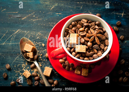 I chicchi di caffè in un rosso tazza di caffè. Nei toni dell'immagine, copia dello spazio. Foto Stock