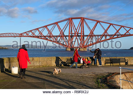 South Queensferry, Regno Unito. Il 28 dicembre, 2018. Le persone che si godono il tempo soleggiato su South Queensferry con il Forth Bridge. Credito: Craig Brown/Alamy Live News Foto Stock