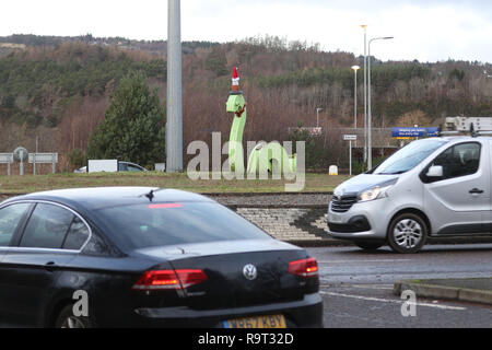 Inverness, Scotland, Regno Unito. Il 29 dicembre 2018. Burloni hanno vestito un punto di riferimento del mostro di Loch Ness in un cono stradale, Santa hat e un tinsel collana. Il legno Nessie è in corrispondenza di una rotatoria sulla strada per il Lago di Loch Ness da Inverness, vicino al negozio Tesco sulla Dores road. L'aggiunta di traffico cono al Nessie landmark è simile al normale aggiunta di un cono stradale per il Duca di Wellington statua in Glasgow. Credito Foto: Andrew Smith/Alamy Live News Foto Stock