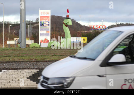 Inverness, Scotland, Regno Unito. Il 29 dicembre 2018. Burloni hanno vestito un punto di riferimento del mostro di Loch Ness in un cono stradale, Santa hat e un tinsel collana. Il legno Nessie è in corrispondenza di una rotatoria sulla strada per il Lago di Loch Ness da Inverness, vicino al negozio Tesco sulla Dores road. L'aggiunta di traffico cono al Nessie landmark è simile al normale aggiunta di un cono stradale per il Duca di Wellington statua in Glasgow. Credito Foto: Andrew Smith/Alamy Live News Foto Stock