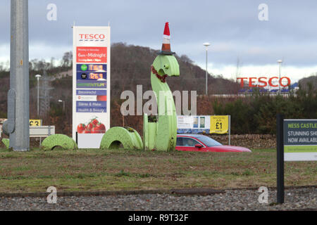 Inverness, Scotland, Regno Unito. Il 29 dicembre 2018. Burloni hanno vestito un punto di riferimento del mostro di Loch Ness in un cono stradale, Santa hat e un tinsel collana. Il legno Nessie è in corrispondenza di una rotatoria sulla strada per il Lago di Loch Ness da Inverness, vicino al negozio Tesco sulla Dores road. L'aggiunta di traffico cono al Nessie landmark è simile al normale aggiunta di un cono stradale per il Duca di Wellington statua in Glasgow. Credito Foto: Andrew Smith/Alamy Live News Foto Stock