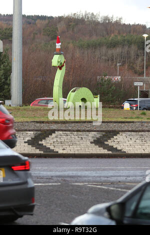 Inverness, Scotland, Regno Unito. Il 29 dicembre 2018. Burloni hanno vestito un punto di riferimento del mostro di Loch Ness in un cono stradale, Santa hat e un tinsel collana. Il legno Nessie è in corrispondenza di una rotatoria sulla strada per il Lago di Loch Ness da Inverness, vicino al negozio Tesco sulla Dores road. L'aggiunta di traffico cono al Nessie landmark è simile al normale aggiunta di un cono stradale per il Duca di Wellington statua in Glasgow. Credito Foto: Andrew Smith/Alamy Live News Foto Stock