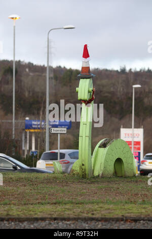 Inverness, Scotland, Regno Unito. Il 29 dicembre 2018. Burloni hanno vestito un punto di riferimento del mostro di Loch Ness in un cono stradale, Santa hat e un tinsel collana. Il legno Nessie è in corrispondenza di una rotatoria sulla strada per il Lago di Loch Ness da Inverness, vicino al negozio Tesco sulla Dores road. L'aggiunta di traffico cono al Nessie landmark è simile al normale aggiunta di un cono stradale per il Duca di Wellington statua in Glasgow. Credito Foto: Andrew Smith/Alamy Live News Foto Stock