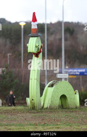 Inverness, Scotland, Regno Unito. Il 29 dicembre 2018. Burloni hanno vestito un punto di riferimento del mostro di Loch Ness in un cono stradale, Santa hat e un tinsel collana. Il legno Nessie è in corrispondenza di una rotatoria sulla strada per il Lago di Loch Ness da Inverness, vicino al negozio Tesco sulla Dores road. L'aggiunta di traffico cono al Nessie landmark è simile al normale aggiunta di un cono stradale per il Duca di Wellington statua in Glasgow. Credito Foto: Andrew Smith/Alamy Live News Foto Stock