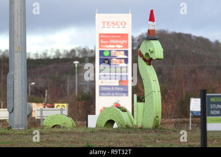 Inverness, Scotland, Regno Unito. Il 29 dicembre 2018. Burloni hanno vestito un punto di riferimento del mostro di Loch Ness in un cono stradale, Santa hat e un tinsel collana. Il legno Nessie è in corrispondenza di una rotatoria sulla strada per il Lago di Loch Ness da Inverness, vicino al negozio Tesco sulla Dores road. L'aggiunta di traffico cono al Nessie landmark è simile al normale aggiunta di un cono stradale per il Duca di Wellington statua in Glasgow. Credito Foto: Andrew Smith/Alamy Live News Foto Stock