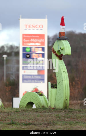 Inverness, Scotland, Regno Unito. Il 29 dicembre 2018. Burloni hanno vestito un punto di riferimento del mostro di Loch Ness in un cono stradale, Santa hat e un tinsel collana. Il legno Nessie è in corrispondenza di una rotatoria sulla strada per il Lago di Loch Ness da Inverness, vicino al negozio Tesco sulla Dores road. L'aggiunta di traffico cono al Nessie landmark è simile al normale aggiunta di un cono stradale per il Duca di Wellington statua in Glasgow. Credito Foto: Andrew Smith/Alamy Live News Foto Stock