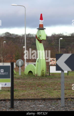 Inverness, Scotland, Regno Unito. Il 29 dicembre 2018. Burloni hanno vestito un punto di riferimento del mostro di Loch Ness in un cono stradale, Santa hat e un tinsel collana. Il legno Nessie è in corrispondenza di una rotatoria sulla strada per il Lago di Loch Ness da Inverness, vicino al negozio Tesco sulla Dores road. L'aggiunta di traffico cono al Nessie landmark è simile al normale aggiunta di un cono stradale per il Duca di Wellington statua in Glasgow. Credito Foto: Andrew Smith/Alamy Live News Foto Stock