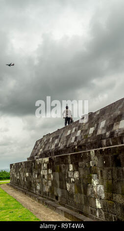 Un turista permanente sulla Ratu Boko Palace Yogyakarta e guardare il piano di volo Foto Stock