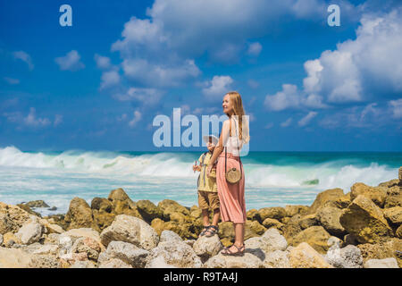 Madre e figlio i viaggiatori su Melasti incredibile spiaggia con acque turchesi, isola di Bali Indonesia. Viaggiare con bambini concept Foto Stock