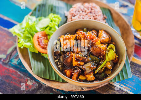 Popolare pasto Balinese di riso con varietà di piatti laterali che sono serviti insieme con il riso e più come extra opzionali Foto Stock