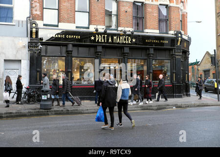 Exterior street view di pedoni che attraversano la strada al di fuori di Pret a Manger Shoreditch East London E2 Inghilterra UK KATHY DEWITT Foto Stock