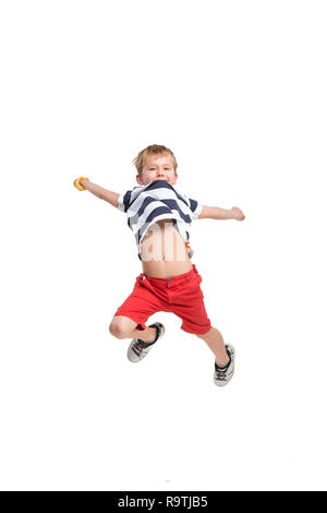 Adorabile bionda boy jumping e alza le mani verso l'alto. Isolato su sfondo bianco. Riprese in studio Foto Stock