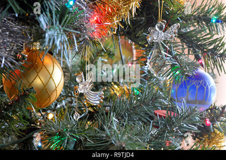 Le palle di Natale e un angelo adornano un albero di Natale nella luce del giorno Foto Stock