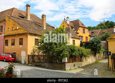 Lastricato in pietra vecchie strade con case colorate in Sighisoara, Romania. Il centro storico della città è un sito Patrimonio Mondiale dell'UNESCO. Foto Stock