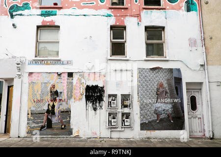 Poster strappati con Vinti Andrews modello sfigurata e strappata con graffiti su una parete in corrispondenza di Turville Street Shoreditch East London E1 KATHY DEWITT Foto Stock