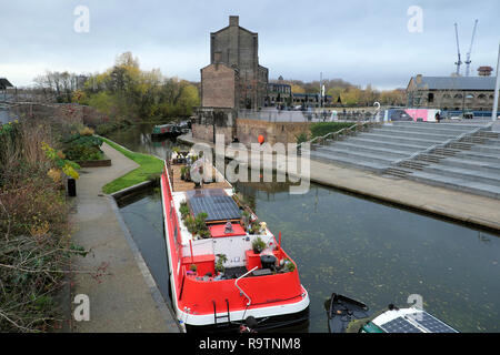 Piante su una casa galleggiante rosso ormeggiato sul Regents Canal vicino piazza granaio & Coal scende cantiere in Kings Cross Londra zona NC1 Inghilterra UK KATHY DEWITT Foto Stock