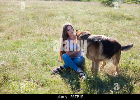 Una donna con un bambino durante una gita con il pastore tedesco di formazione Foto Stock