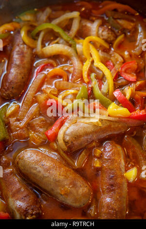 La cottura di salsiccia e cipolla rossa e gialla di peperoni verdi in cucina pan Foto Stock