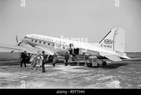 Un BEA, British European Airways, Douglas DC-3 aereo, registrazione G-AIWD, a terra in un aeroporto in Inghilterra. Essa ha appena sbarcati e i passeggeri sono lo sbarco dell'aeromobile. Fotografia in bianco e nero presa verso la metà degli anni cinquanta. Foto Stock