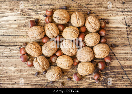 Le noci, le nocciole e cedro al buio su un sfondo di legno vecchio. Noce sana nutrizione. Foto Stock