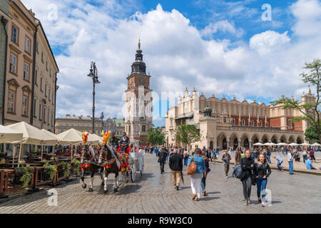 Cavallo e Carrozza di fronte al Municipio Torre (Wieża ratuszowa) e panno Hall (Sukiennice) nella piazza principale (Piazza Rynek Główny), Cracovia, in Polonia Foto Stock