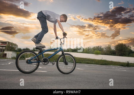 Ragazzo giovane facendo acrobazie pericolose in bici Foto Stock