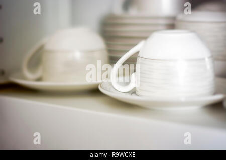 Decorate tazze da caffè tenute in un ripiano di una dispensa bianco. Interior shot Foto Stock