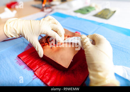 Militare tedesco medic pratica di controllo spurgo su un manichino di ferita Foto Stock