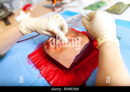 Militare tedesco medic pratica di controllo spurgo su un manichino di ferita Foto Stock