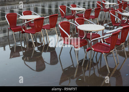 Street Cafe raffigurato durante l'acqua alta (l'acqua alta in Piazza San Marco a Venezia, Italia. Foto Stock