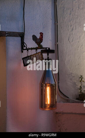 Lampada di arte di strada appesa al muro, Grecia, isola di Amouliani, mar Egeo, Halkidiki Foto Stock