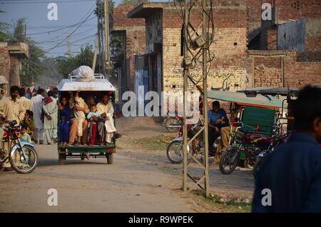 Un motociclo o rikshaw tukuk con gente seduta in esso. Una vista da rurale Sindh, Pakistan. Foto Stock