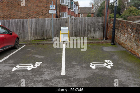 Parcheggio bay per la ricarica dei veicoli elettrici. Parcheggio a pagamento qui in Tenterton, Kent, England, Regno Unito Foto Stock