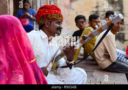 Jodhpur, Rajasthan, India, 2019. Rajasthani tradizionale sarangi player nel suo abito tradizionale e la testa dentata turbante rosso pagdi giocando sarangi. Foto Stock