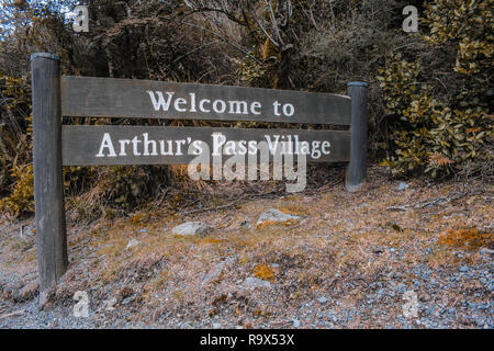 Benvenuto a Arthur's Pass Village segno, strada in legno segno, in Arthur's Pass, Canterbury, Nuova Zelanda Foto Stock