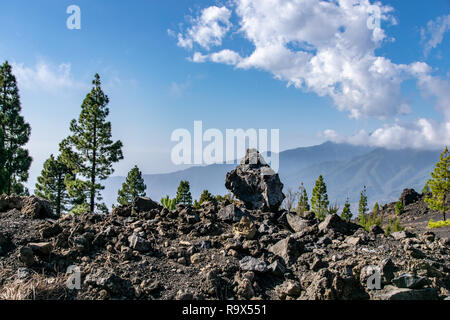 Le rocce vulcaniche guardando verso di mountain range al Mirador Del Llano del Jable, La Palma Isole Canarie Foto Stock