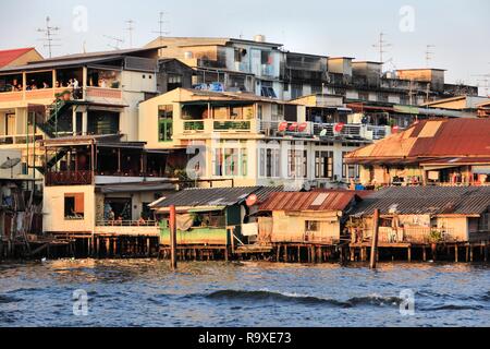 BANGKOK, Tailandia - 24 dicembre 2013: vista sul fiume di architettura povera in Bangkok. Bangkok è la città più grande della Tailandia con 14 milioni di persone livi Foto Stock
