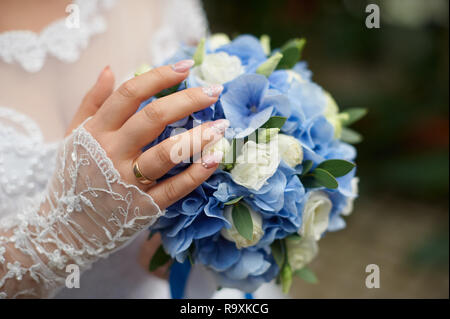 Sposa tiene in mano un bellissimo matrimonio bouquet di rose Foto Stock