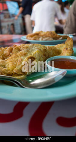 La prima colazione a Bangkok, Thailandia, frittata con salsa di peperoncino su una piastra di turchese Foto Stock