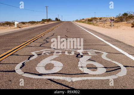 Un percorso 66 scudo è dipinta su un tratto deserte della storica strada nel deserto di Mojave, tra Helendale e Lenwood, California. Foto Stock