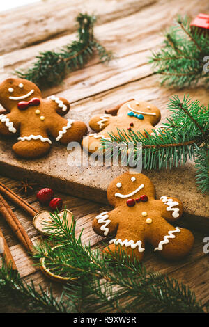 Gastronomia natalizia. Gingerbread Man cookies in impostazione di Natale. Xmas dessert. Tavola di natale Foto Stock