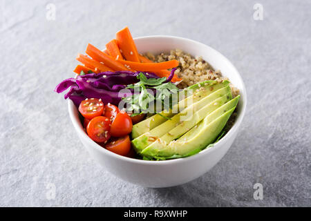 Buddha vegano ciotola con fresche verdure crude e quinoa su sfondo grigio Foto Stock