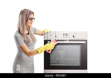 Giovane donna con guanti pulizia di un forno isolato su sfondo bianco Foto Stock