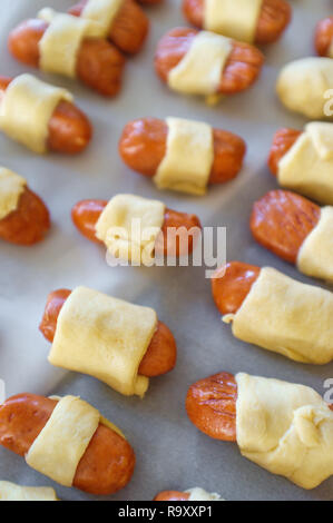 Maiale cruda in una coperta hotdog avvolto in pasta croissant pronto per essere cotto al forno Foto Stock