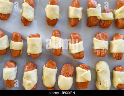 Maiale cruda in una coperta hotdog avvolto in pasta croissant pronto per essere cotto al forno Foto Stock