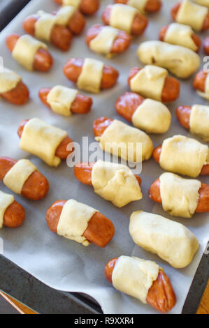 Maiale cruda in una coperta hotdog avvolto in pasta croissant pronto per essere cotto al forno Foto Stock
