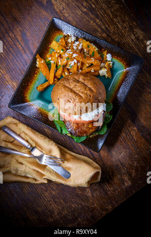 Portobello sandwich a fungo con formaggio di capra pesto e lato di Greco patata dolce patate fritte Foto Stock