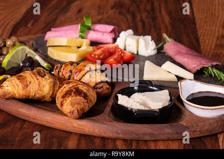La prima colazione con marmellata, formaggio, brioche, insalata, salame e olive. Buffet svedese Foto Stock